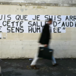 Un homme passe devant un collage d'une phrase prononcée par Gisele Pelicot au procès de Mazan, à Avignon, le 10 octobre 2024. © Christophe SIMON / AFP